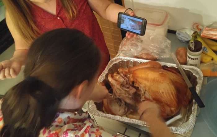 Cutting up turkey with the guidance of YouTube. Faces hidden to protect the innocent.